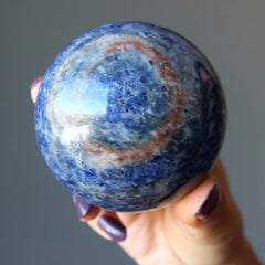 hand holding blue sodalite sphere
