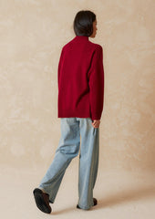 A woman wearing an oversized mockneck sweater.