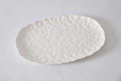 The PAMPA BAY Willow White Platter Oval Large features a textured, slightly wavy ceramic surface and edges in a spacious, empty white design, displayed on a plain white background.