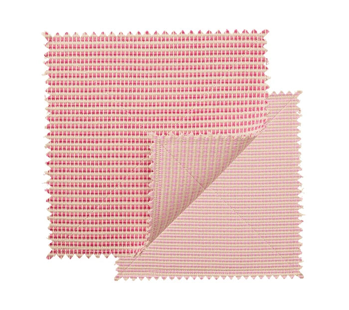 Two square fabric swatches in blush and pink with zigzag edges overlap, one partly folded to reveal both sides, highlighting the chic design of the Kim Seybert Duet Placemat Set of 4 - Blush & Pink.