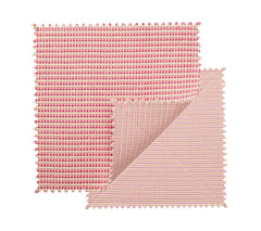 Two square fabric swatches in blush and pink with zigzag edges overlap, one partly folded to reveal both sides, highlighting the chic design of the Kim Seybert Duet Placemat Set of 4 - Blush & Pink.