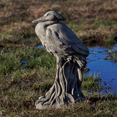 Egret standing on a plinth by water