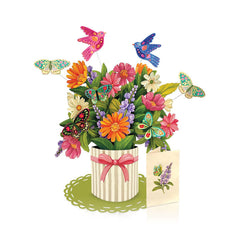 Colorful flower arrangement with butterflies and a card on a white background