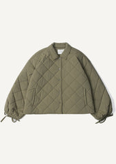 A woman wearing a quilted, padded jacket in army green with tie detail at wrists.