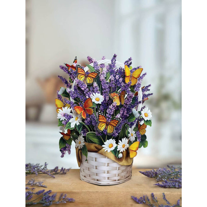 Bouquet of flowers with butterflies in a white basket on a wooden surface.