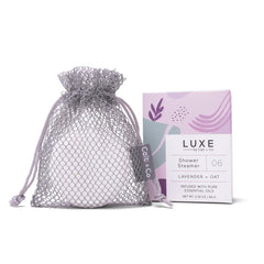 Luxe shower steamer packaging with a mesh bag on a white background