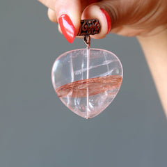hand holding red fire quartz pendant