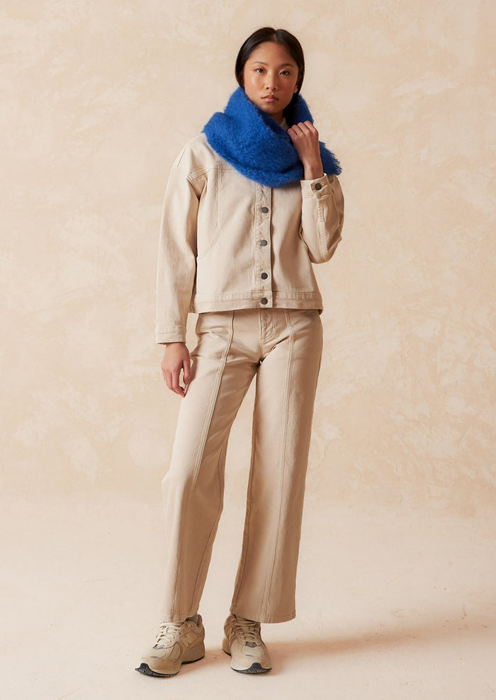 A pair of ecru wide leg jeans with vertical seam down front.