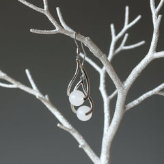hand holding snow quartz dangle earrings