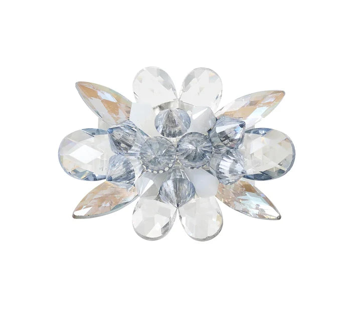 The Kim Seybert Spectra Napkin Ring Set of 4 in Glacier Blue features faceted clear and light blue gemstones arranged as petals with a clustered center—an elegant accent for your table décor or a unique crystal napkin ring.