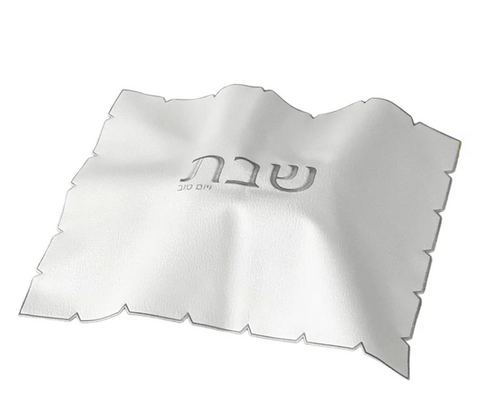 The BT-Shalom White Embroidered Leatherette Challah Cover—Silver features scalloped edges and central Hebrew text, making it an elegant Shabbat accent.