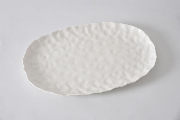 The PAMPA BAY Willow White Platter Oval Large features a textured, slightly wavy ceramic surface and edges in a spacious, empty white design, displayed on a plain white background.