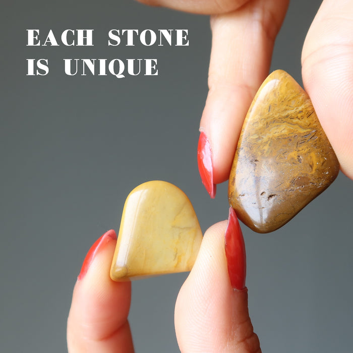 hand holding yellow jasper tumbled stones
