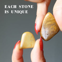 hand holding yellow jasper tumbled stones